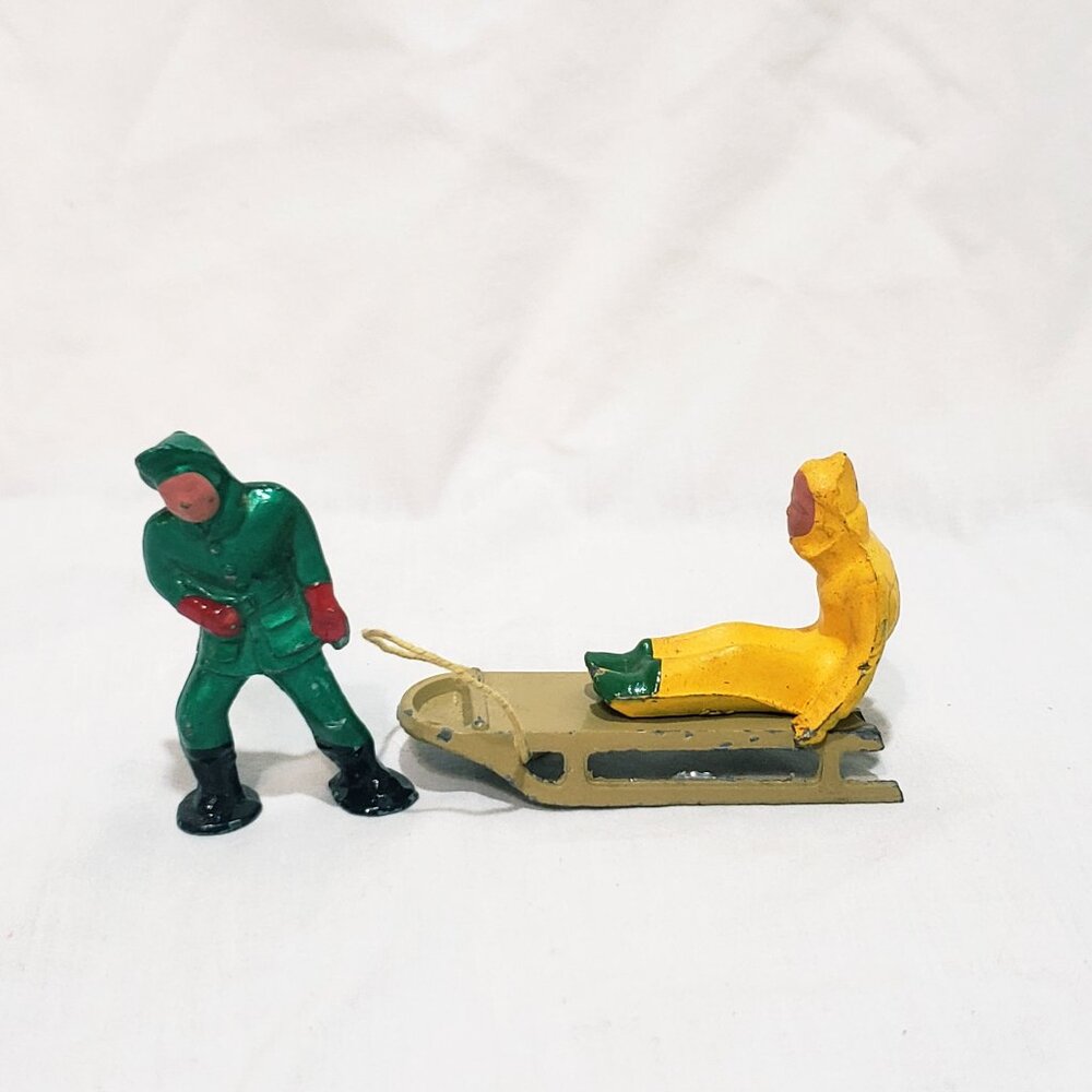 Vintage Antique Winter Christmas Barclay Lead Man Pulling Person on Sled 2.5"